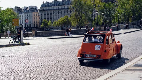 Un lumineux de taxi parisien rouge et vert la nuit, avec un écran de dispatch G7 brillant sur le tableau de bord