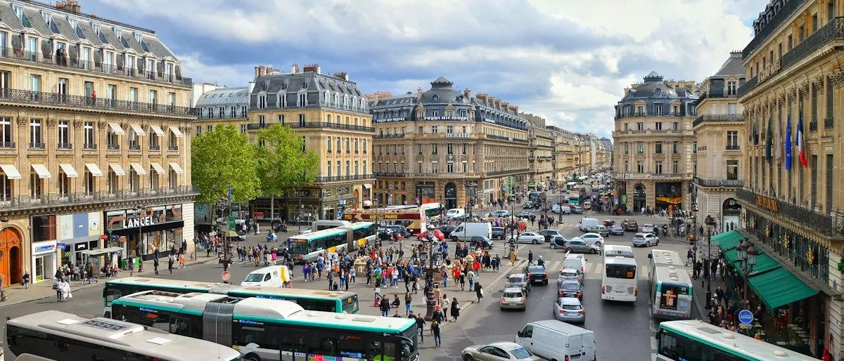 Un chauffeur de taxi parisien adossé à son véhicule lumineux allumé, lisant attentivement un contrat de location-gérance