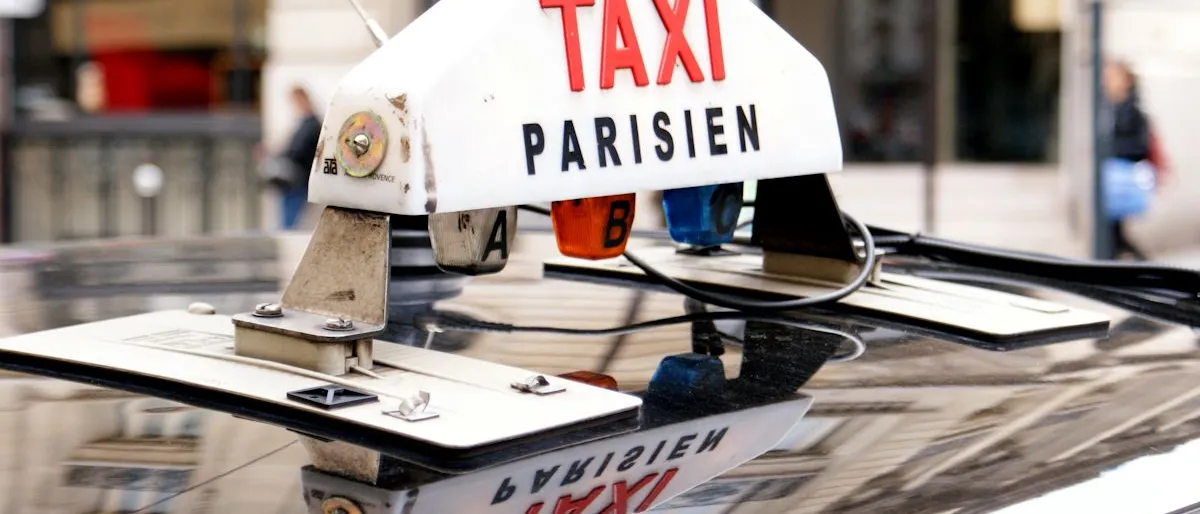 Le lumineux « TAXI PARISIEN » sur le toit d'un taxi, symbole de la licence ADS au cœur du choix entre louer et acheter.